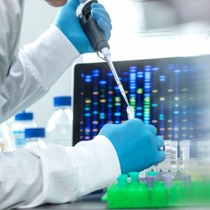 Wissenschaftlerin pipettiert Probe in ein Fläschchen für DNA-Tests