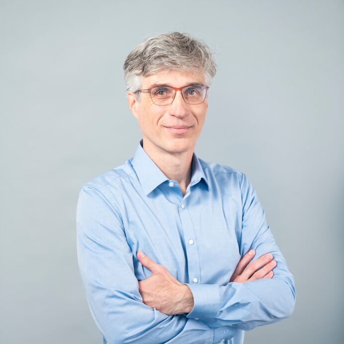 Hämatopathologie Lübeck - Priv.-Doz. Dr. med. Heinz-Wolfram Bernd - Facharzt für Pathologie Porträt von Priv.-Doz. Dr. med. Heinz-Wolfram Bernd. Er trägt ein hellblaues Hemd, eine Brille und posiert mit verschränkten Armen vor einem neutralen Hintergrund.